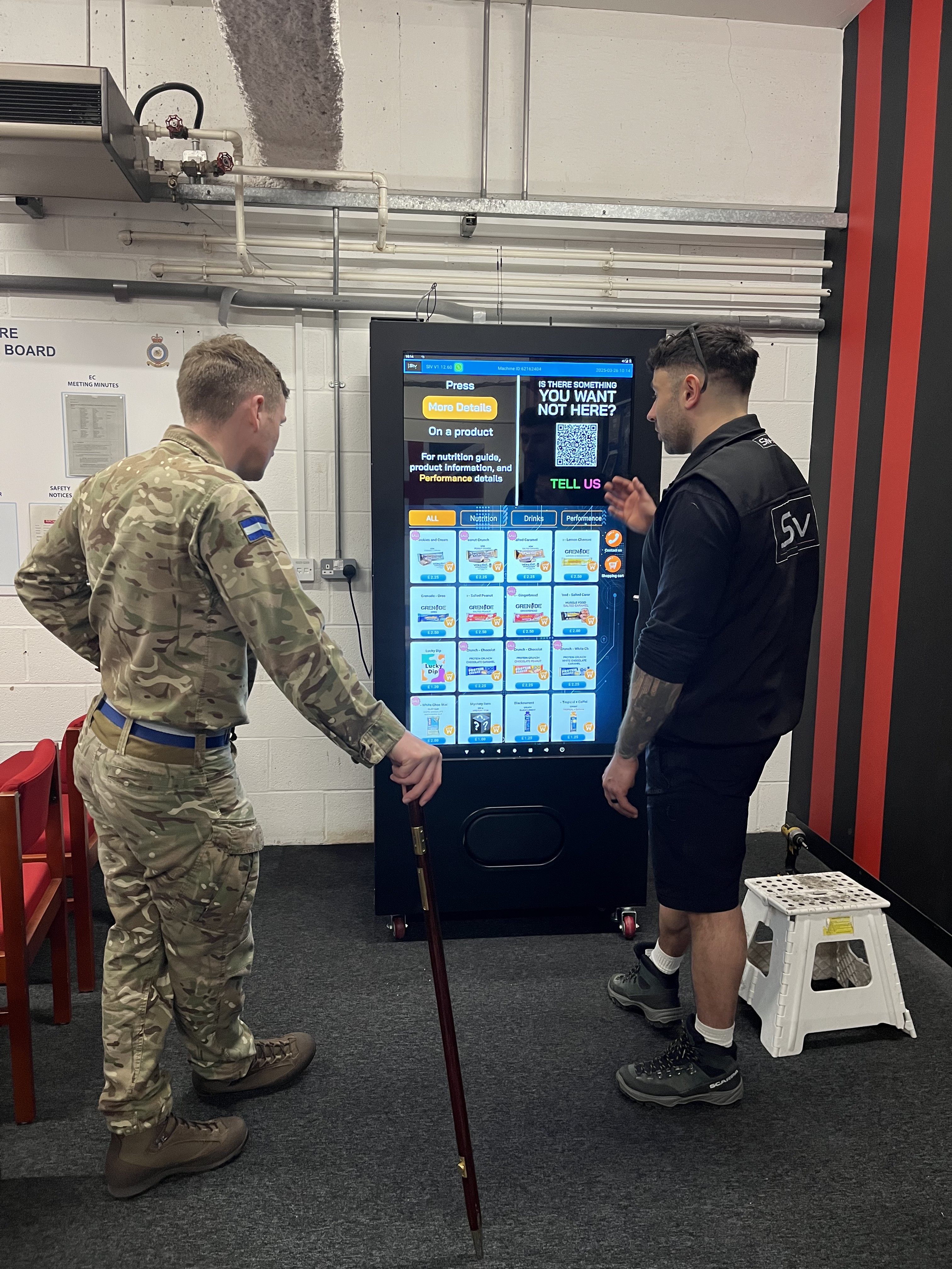 SIV representative demonstrating an interactive vending machine to a uniformed service member.